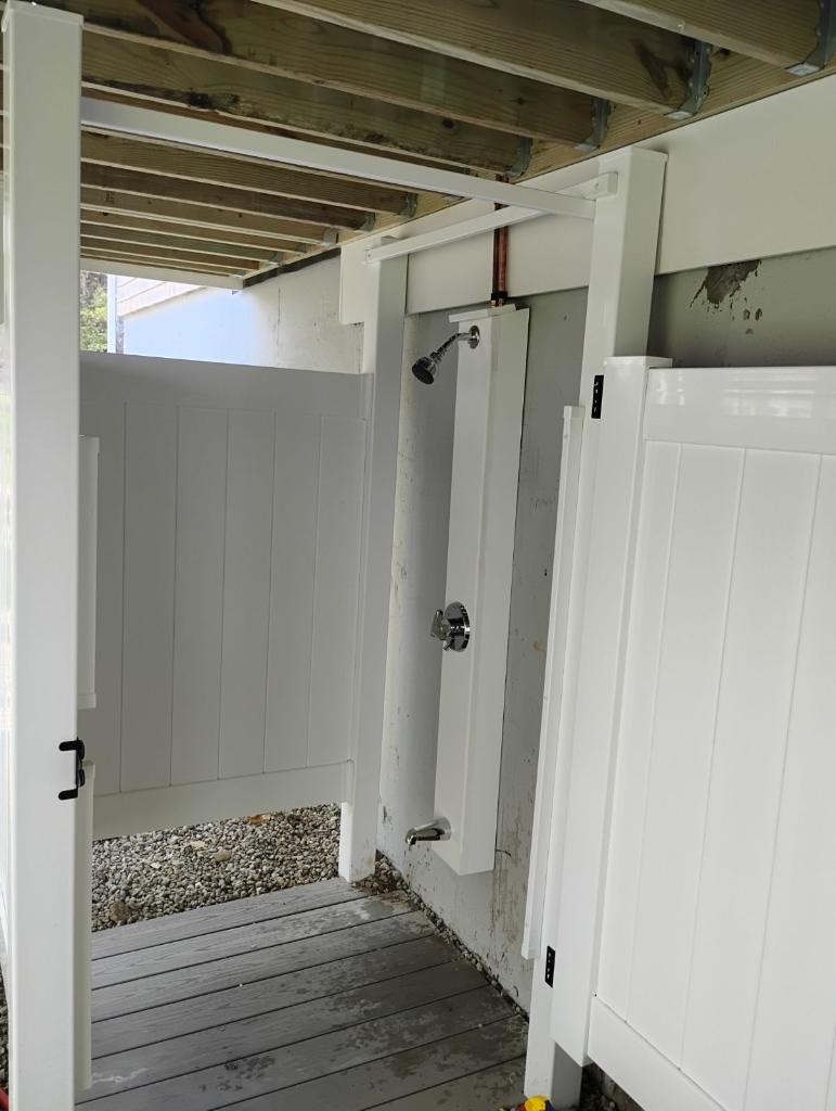 Outdoor shower enclosure with white privacy panels